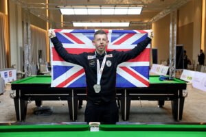 David Church holds up the UK flag after winning the silver medal at the 2023 World Abilitysport Games