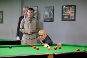 Neville Helou plays a shot while Leroy Williams looks on behind him