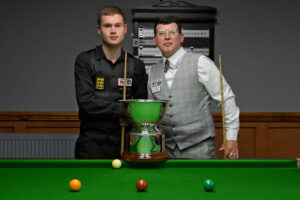 Matthew Haslam and Leroy Williams shake hands by the trophy ahead of their 2024 Champion of Champions final.