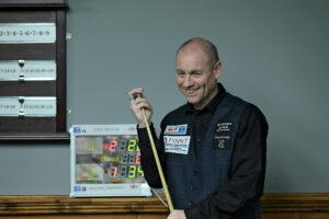 Dave Bolton smiles while chalking his cue during the 2024 Champion of Champions at Landywood Snooker Club