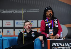 David Church sits in his seat during the 2024 Shanghai Disability Invitational while Kal Mattu watches on