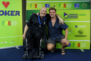 Dave Beaumont, wearing his gold medal, poses with his son after victory in Portugal