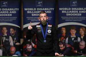 David Church stands by the table holding up one finger after becoming the world number one