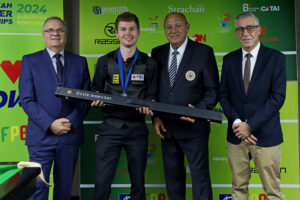 Matthew Haslam is presented with a Little Monster cue by Nigel Mawer QPM, Maxime Cassis and Ricardo Salgado