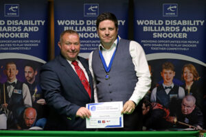 Daniel Kelly is presented with his medal by tournament director Stuart Barker