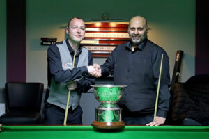 Alan Reynolds and Mohammed Faisal Butt shake hands prior to the 2023 Champion of Champions final