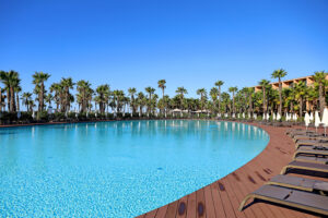 The pool area, surrounded by palm trees, at the Vidimar Hotel & Resort in Albufeira